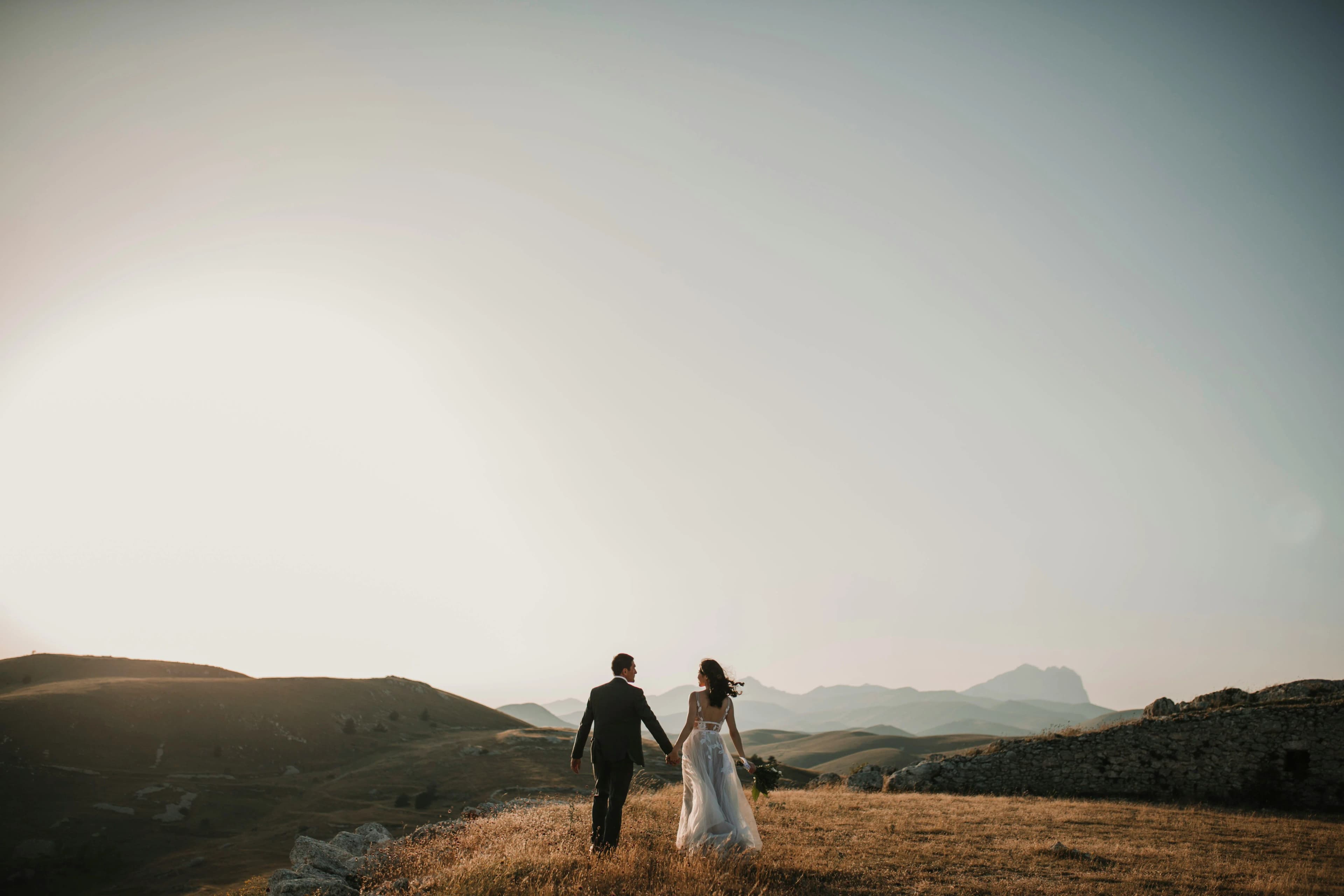 Couple walking hand in hand at golden hour